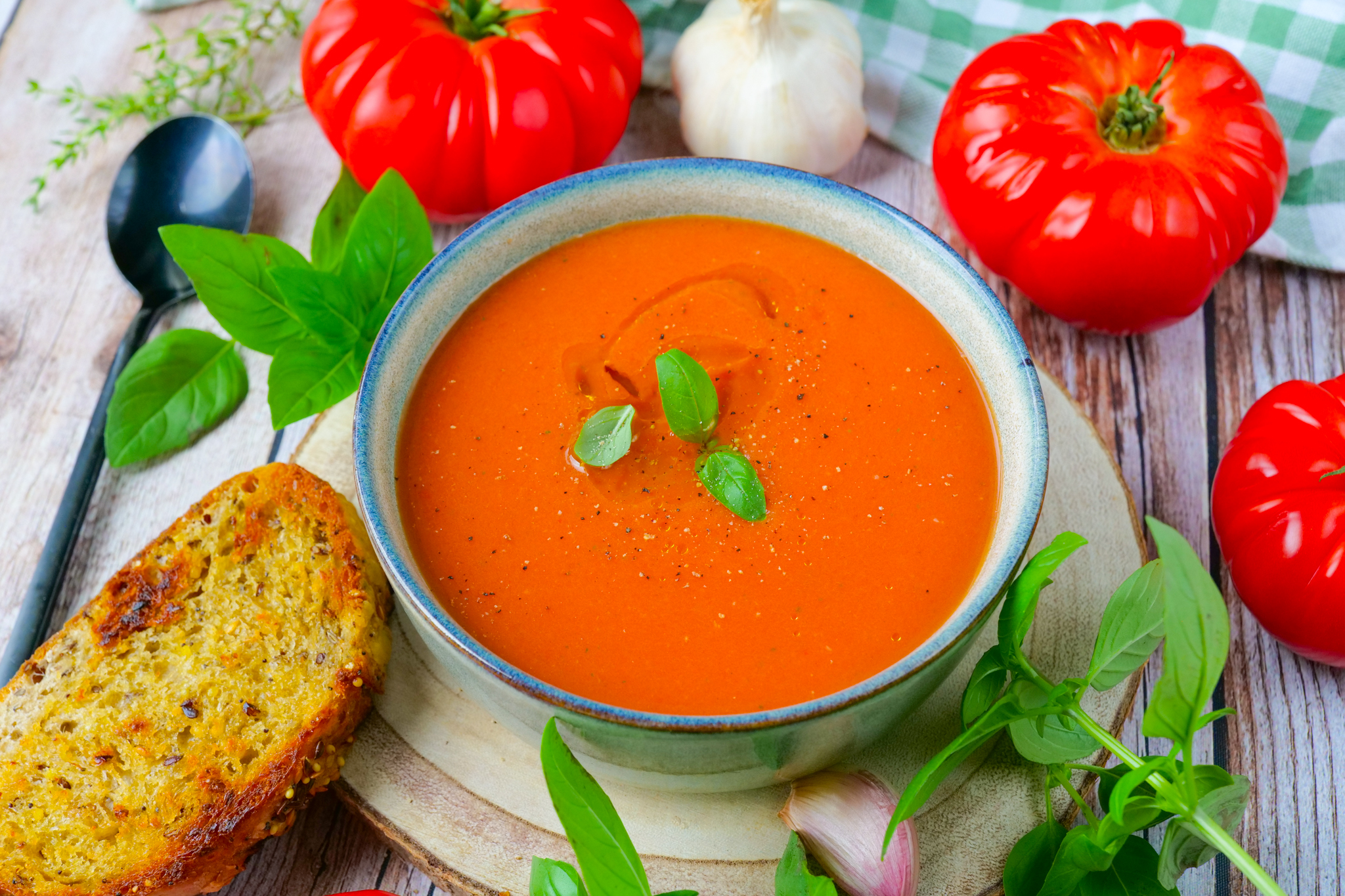 Roasted Tomato and Garlic Soup in a white bowl with fresh basil